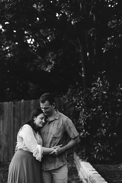 Mom, dad and their 2 boys playing in their backyard.