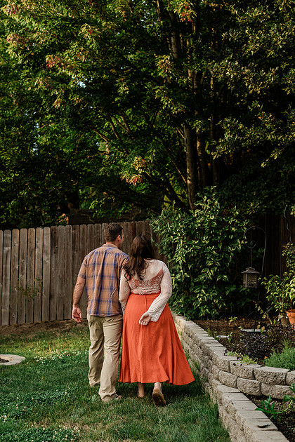 Mom, dad and their 2 boys playing in their backyard.