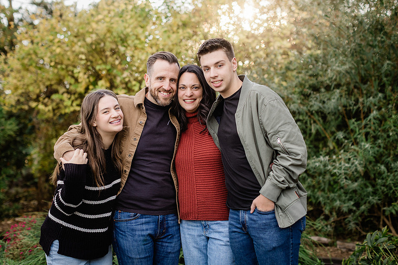 Family of 4 with teens in a garden during the fall season