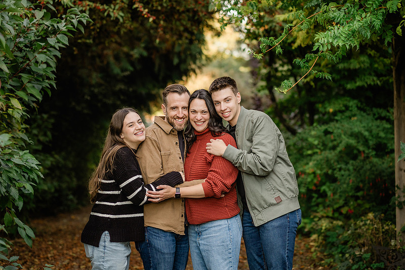 Family of 4 with teens in a garden during the fall season