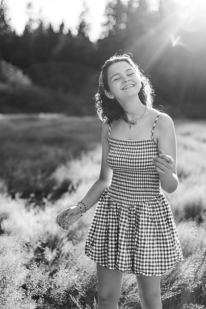 2 female friends playing in a field with trees