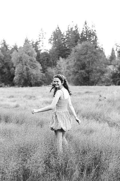 2 female friends playing in a field with trees