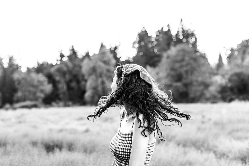2 female friends playing in a field with trees