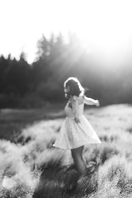 2 female friends playing in a field with trees