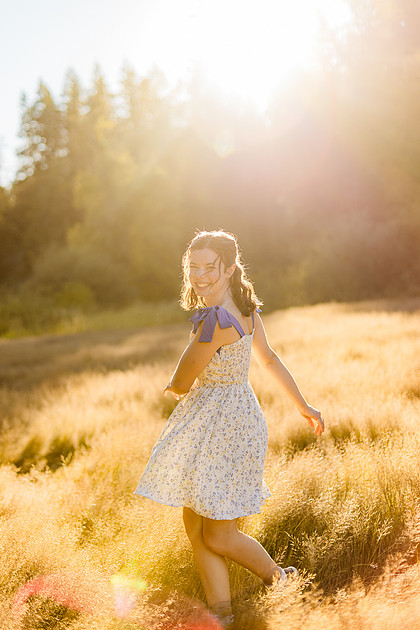 2 female friends playing in a field with trees