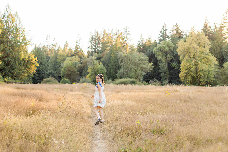 2 female friends playing in a field with trees
