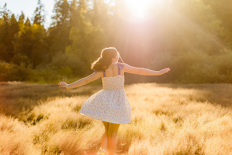 2 female friends playing in a field with trees
