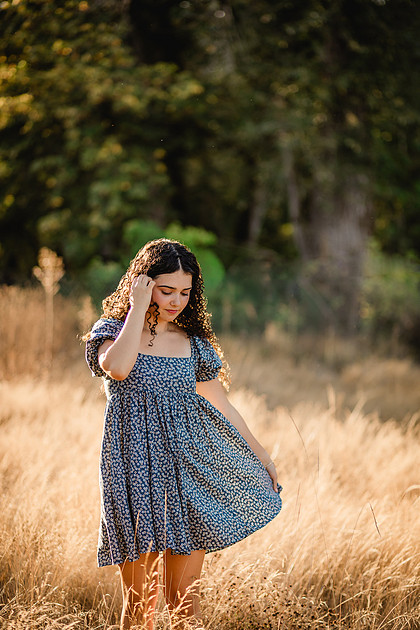 Senior girl wearing a white dress and blue dress in a field and garden in Vancouver, WA