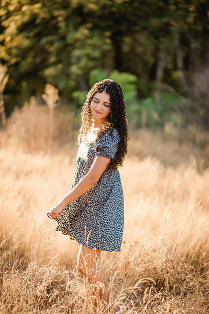 Senior girl wearing a white dress and blue dress in a field and garden in Vancouver, WA