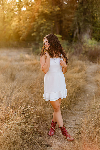 Senior girl wearing a white dress and blue dress in a field and garden in Vancouver, WA
