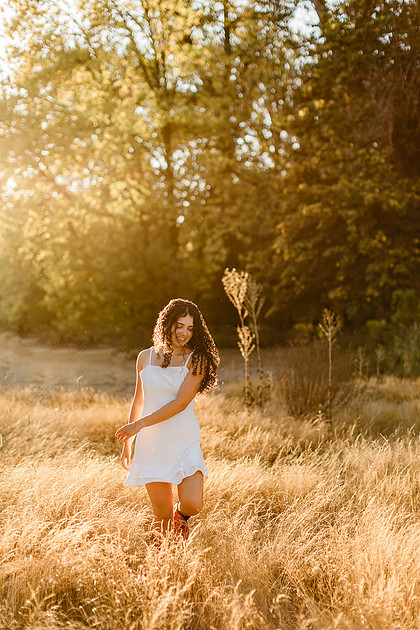 Senior girl wearing a white dress and blue dress in a field and garden in Vancouver, WA