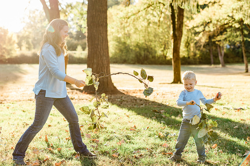 a boy, his mom and their dog playing by the river