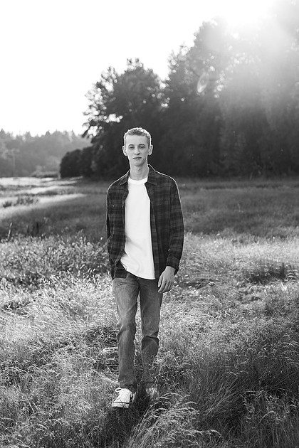 Senior boy in a field with large trees