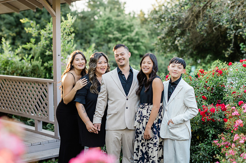 portrait of a family of five in a garden wearing more formal clothing